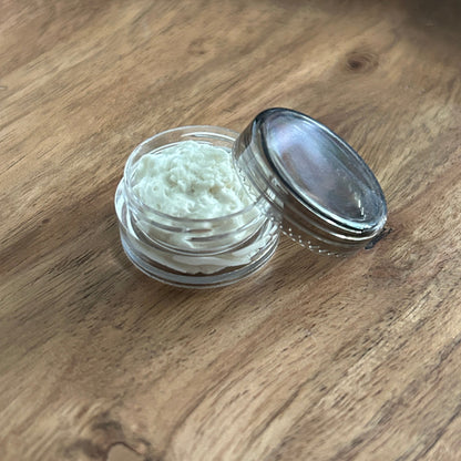 Small container with body butter on a wooden surface